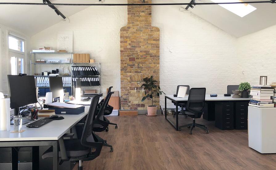 Four desks in a bright, creative warehouse studio in the heart of Queens Park