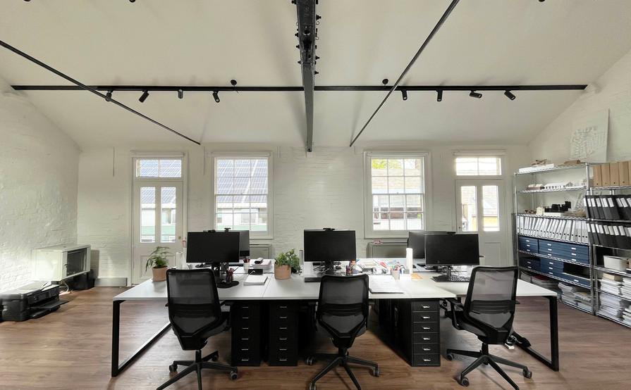 Four desks in a bright, creative warehouse studio in the heart of Queens Park