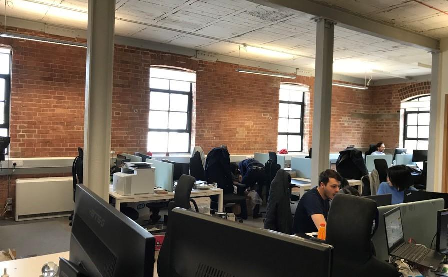 DESKS IN LIGHT AIRY TOP FLOOR WITH HIGH CEILINGS AND LARGE WINDOWS